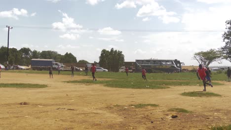 Africano-Pateando-Una-Pelota-De-Fútbol-Al-Lado-De-Una-Carretera-Transitada-En-Kampala