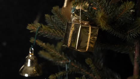 Christmas-tree-season-golden-wrapped-gift-box,-sliding-shot