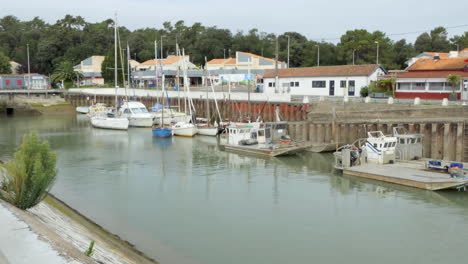 Boats-docked-in-the-port-on-the-island-of-Oleron,-mirrored-effect-in-the-water