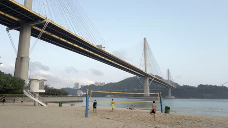 Young-Men-playing-beach-Volleyball-in-Hong-Kong,-Lido-beach