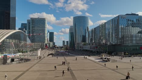 Commuters-and-workers-move-around-on-the-forecourt-in-front-of-the-Grand-Arch