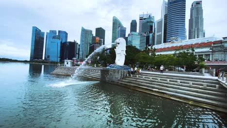 Merlion-Statuenbrunnen-Mit-Touristen-Und-Der-Skyline-Der-Innenstadt-Im-Hintergrund