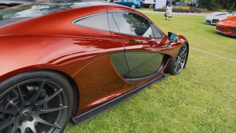 Toma-En-Movimiento-De-Un-Hermoso-Mclaren-Rojo-En-Una-Exhibición-De-Autos