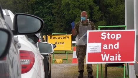 Armeekrankenschwester-Mit-Gesichtsmaske-Führt-Fahrzeuge-Im-Tierheim-Des-Corona-Covid-Virus-Testzentrums