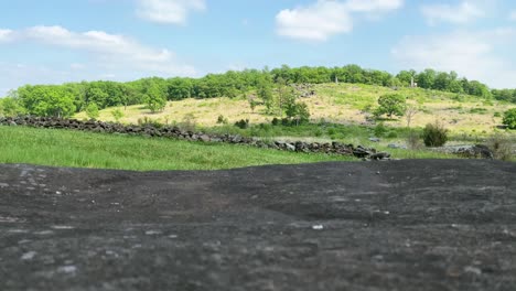 Tilt-up-view-of-Little-Round-Top-site-of-American-Civil-War-battle-in-Gettysburg,-rock-wall