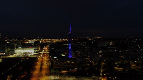 Night-aerial-view-of-Elisa-communication-tower-in-Pasila,-Helsinki-Finland