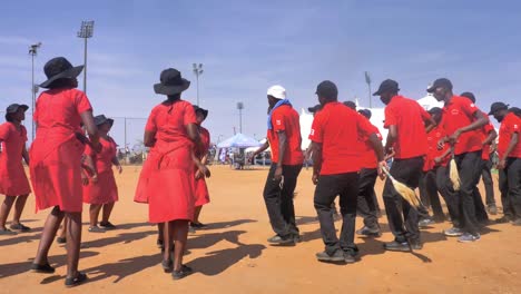 Hombres-Y-Mujeres-Africanos-Bailando-En-Un-Evento-Cultural-Vestidos-De-Rojo