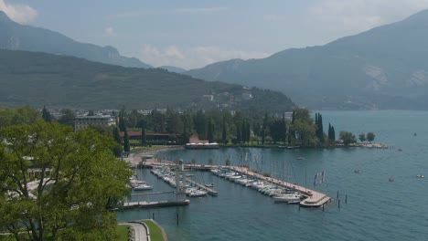 Luftdrohnenansicht-Der-Italienischen-Alpen-Und-Des-Gardasees-Mit-Dem-Yachthafen-Von-Riva-Del-Garda-In-Norditalien
