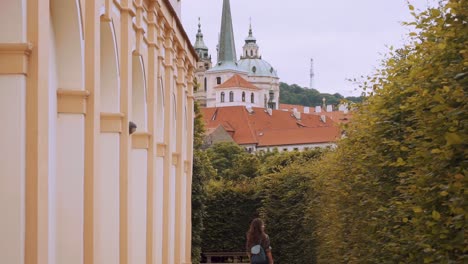 Panorámica-Hacia-Abajo-Revelan-A-Una-Turista-Caminando-Junto-A-Un-Seto-En-Los-Jardines-De-Waldstein-En-Praga