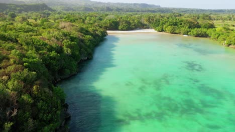 Epischer-Flug-über-Den-Gewässern-Des-Diamante-Beach-In-Cabrera,-Dominikanische-Republik,-Neben-Dem-Klaren-Blauen-Meer-Und-Blick-Auf-üppige-Grüne-Bäume-Und-Landschaften-An-Einem-Wundervollen-Tag