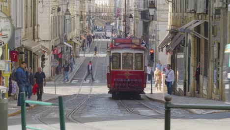 Ein-Blick-Auf-Die-Lissabonner-Straßenbahn,-Die-Sich-Auf-Ihrem-Gleis-Bewegt,-Wo-Viele-Touristen-Die-Altstadt-Von-Portugal-Besuchen