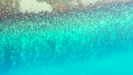 Überfliegen-Sie-Das-Aquamarinblaue-Meerwasser-Mit-Einem-Korallenriff-Und-Nähern-Sie-Sich-Einem-Wunderschönen-Strand-Mit-Granitfelsen