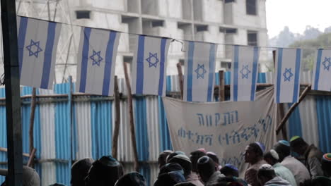 Ethiopian-Jews-Gather-in-Synagogue-to-Pray,-Wide-Shot-of-Row-of-Men,-Slow-Motion