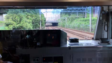 Metro-cockpit-view-on-the-C-Line-passing-a-street-traffic-bridge-with-people-reflected-on-the-glass,-Handheld-shot