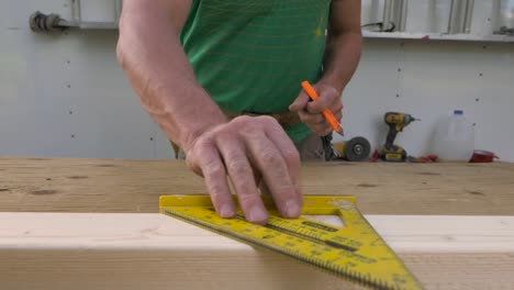 Ein-Tischler-Sah,-Wie-Er-Ein-Stück-Holz-Auf-Den-Tisch-Legte-Und-Mit-Einem-Winkel-Einen-45-Grad-Winkel-Darauf-Markierte