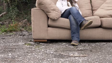 Woman-relaxing-on-sofa-in-outside-yard-wide-shot