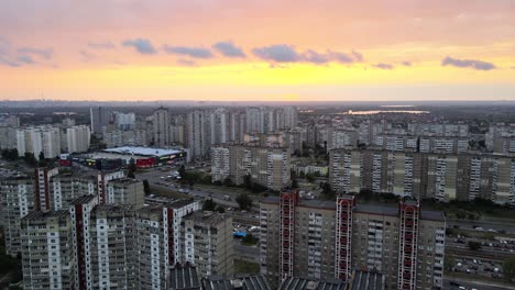 Aerial-view-overlooking-old-buildings-and-the-subway-underground-system,-in-Troieshchyna-soviet-district,-during-sunset,-in-Kiev,-Ukraine---pan,-drone-shot