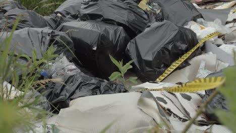Plastic-bag-liners-of-garbage-dumped-in-countryside-medium-shot
