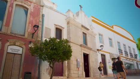Portugal-Algarve-Loule-Estrecha-Calle-De-Piedra-Con-Peatones-Caminando-Al-Sol-De-La-Mañana-4k