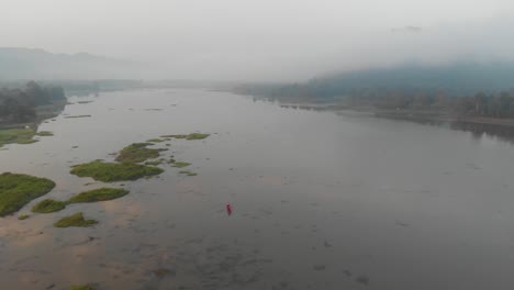 Epische-Luftlandschaftsansicht-Des-Sees,-Umgeben-Von-Bergen,-Die-Mit-Nebel-Bedeckt-Sind
