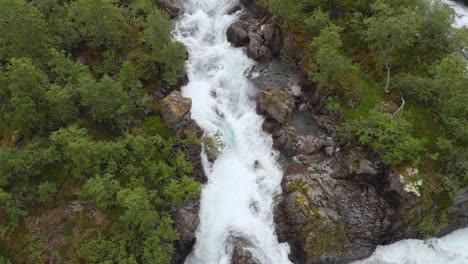 Waterfall-cascading-down-mountainside,-glacial-meltwater,-aerial-view