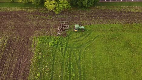 Top-down-View-Of-A-Lush-Field-In-Monroe-County,-Michigan-With-Tillage-Tractor-Tilling-The-Land---high-angle-shot
