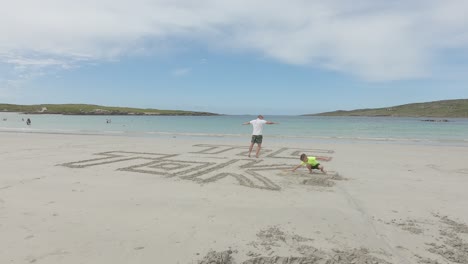 Mann-Schreibt-Tik-Tok-Auf-Den-Strandsand-Neben-Seinem-Fuß,-Wellen-Spülten-Den-Sand-Und-Schrieben-An-Einem-Sommertag-Am-Strand-Der-Hundebucht-In-Connemara,-Irland-–-Zeitraffer