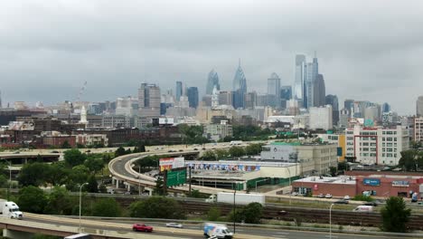 Luftaufnahme-Der-Skyline-Von-Philadelphia,-Fließender-Verkehr-Mit-Wolkenkratzern-In-Der-Ferne-An-Einem-Bewölkten-Sommertag