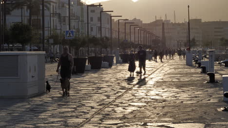 Menschen,-Die-Bei-Sonnenuntergang-Auf-Der-Hafenpromenade-In-Ibiza-Spazieren