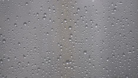 Regentropfen-Auf-Verschwommenem-Glasfenster---Regnerische-Tageselemente---Nahaufnahme