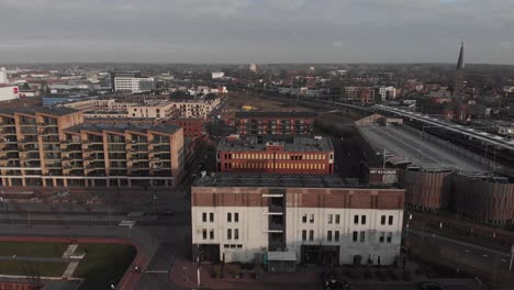 Vista-Aérea-Sobre-El-Edificio-Het-Koelhuis,-Anteriormente-Un-Almacén-De-Mantequilla-En-El-Barrio-De-Noorderhaven,-Donde-En-La-Parte-Superior-Se-Planea-Una-Terraza-En-La-Azotea-Como-Punto-Central-En-La-Nueva-Zona-Residencial