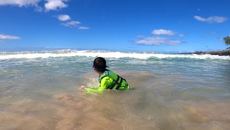 Niño-Con-Un-Chaleco-Salvavidas-Verde-Fluorescente-Hecho-Por-Airhead-En-Unas-Vacaciones-En-Una-Playa-Tropical-En-La-Isla-Grande,-Hawaii