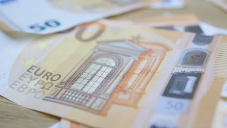 Male-Hand-borrowing-a-50-euro-bill,-from-a-pile-of-money-and-gives-it-back