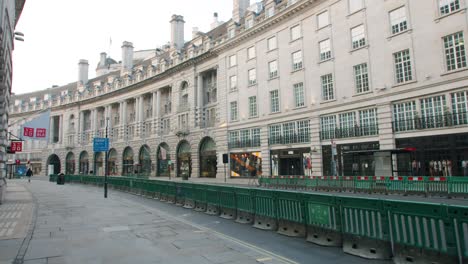 Lockdown-in-London,-empty-Regent-Street,-during-the-Coronavirus-2020-pandemic,-with-COVID-19-barriers-and-signs