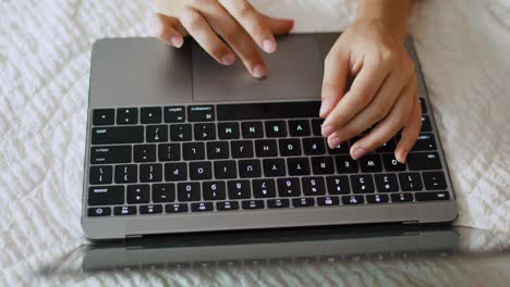 Female-hands-typing-on-laptop-keyboard-and-touchpad