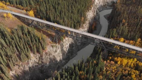 Aerial-View-of-Steel-Bridge-Above-River-and-Canyon,-Scenic-Roadway-in-Alaska-USA-on-Sunny-Day