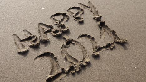 Hand-writing-happy-2021-in-the-sand-at-sunset-with-beautiful-lighting