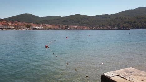 Panning-view-of-the-coast-of-Vela-Luka,-Croatia,-with-an-almost-empty-newly-built-concrete-pier