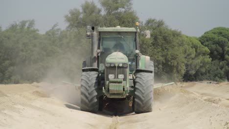 Traktor-Pflügt-Erde-Mit-Planierschild-Auf-Dem-Bauernhof-Und-Fährt-Auf-Die-Kamera-Zu,-Zeitlupe