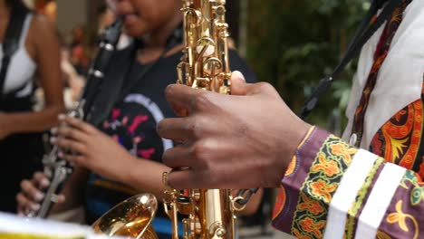 Sweeping-Shot-Close-Up-of-Man-Playing-Saxophone-in-Traditional-Clothing