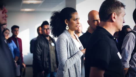 Woman-with-a-group-of-people-looking-out-of-a-window-in-an-office