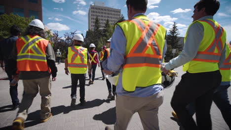 Grupo-De-Trabajadores-De-La-Construcción-Caminando-Hacia-Un-Lugar-De-Trabajo