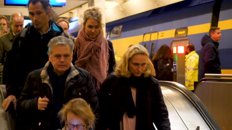 Während-Der-Hauptverkehrszeit-Fahren-Pendler-Eine-Rolltreppe-An-Einem-Bahnhof-Hinunter