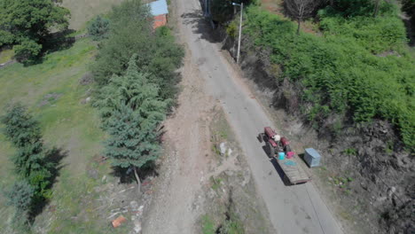 Aerial-tracking-shot-of-a-old-tractor-in-a-rural-village-in-the-north-of-Portugal