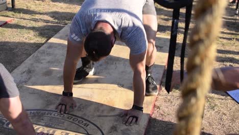 Hombres-Caucásicos-Atléticos-Haciendo-Flexiones,-Flexiones-En-Una-Competencia-De-Crossfit,-Un-Ejercicio-Militar-Popular-Excelente-Para-Desarrollar-Los-Músculos-Pectorales,-Bíceps-Y-Tríceps