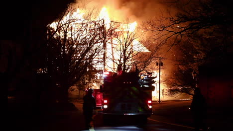 Ein-Feuerwehrauto-Fährt-Langsam-Rückwärts,-Im-Hintergrund-Zeichnet-Sich-Ein-Riesiges-Loderndes-Inferno-Ab,-Historisches-Shakespeare-Theater-In-Stratford,-CT