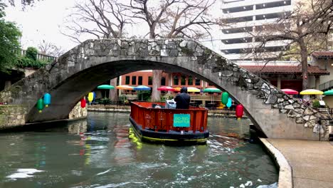 Los-Barcos-Fluviales-Patrullan-Las-Rutas-Del-Paseo-Fluvial-Para-Transportar-A-Los-Visitantes-Por-Los-Restaurantes,-Las-Vistas-Y-Los-Sonidos-De-La-Zona