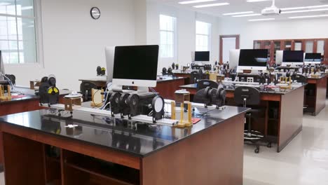 Una-Toma-De-Carro-Suave-Que-Muestra-Filas-De-Computadoras-De-Escritorio-Y-Equipo-De-Laboratorio-En-Un-Salón-De-Clases-De-Física-De-La-Universidad-Estadounidense