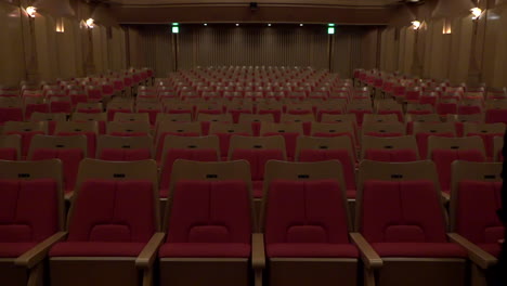 A-staff-is-checking-a-line-of-chairs-at-Oji-Hall,-Ginza,-Tokyo,-Japan,-2018