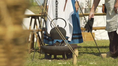 Idyllic-campsite-with-tea-pot-kettle-boiling-over-open-fire